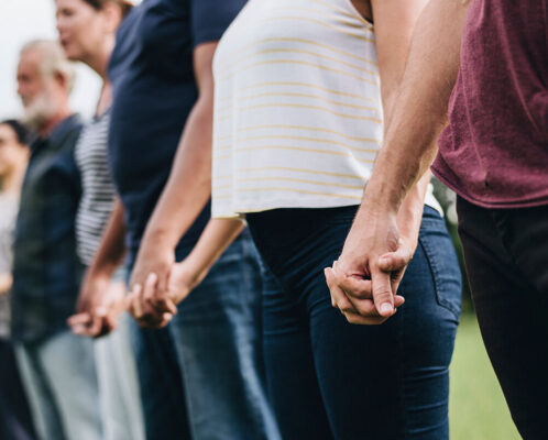 happy-diverse-people-holding-hands-park (1)