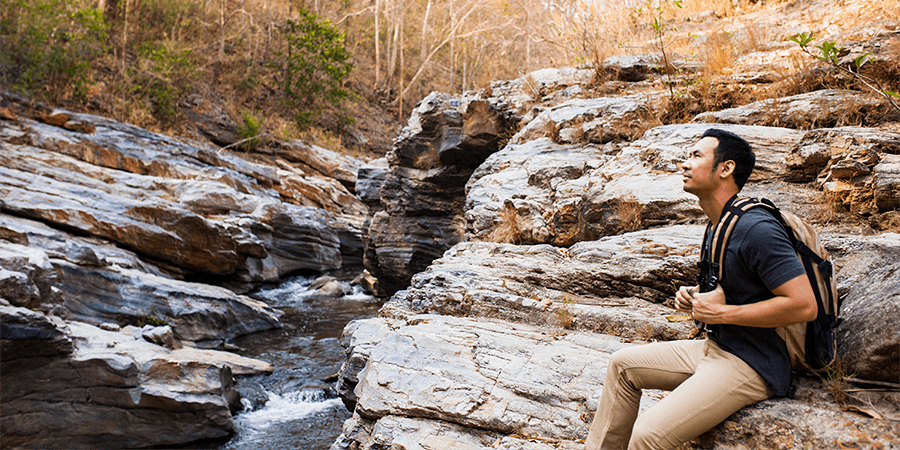 guy-sitting-rocks-near-river (1)