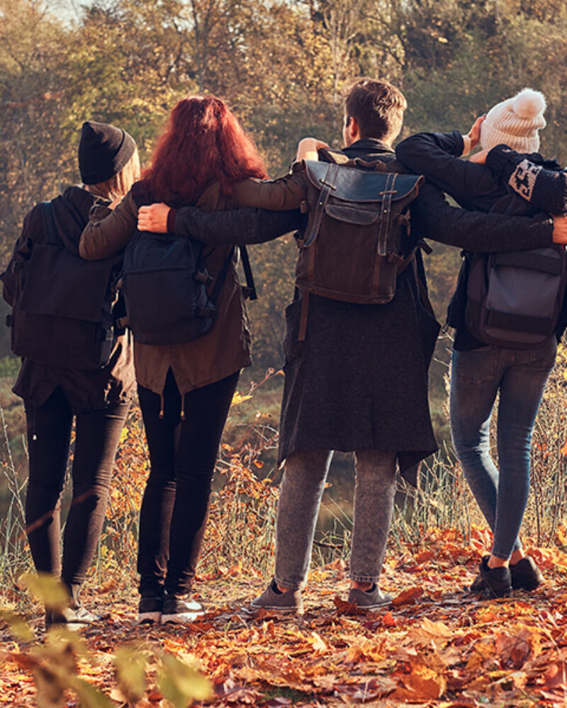 travel-hiking-adventure-concept-back-view-young-friends-hugging-together-looking-lake-beautiful-autumn-forest (1)